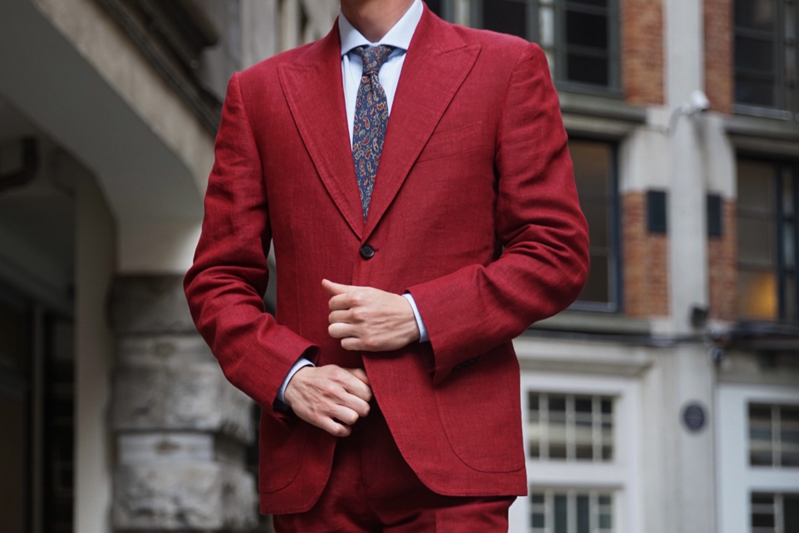 Man wearing bespoke linen red suit with tie